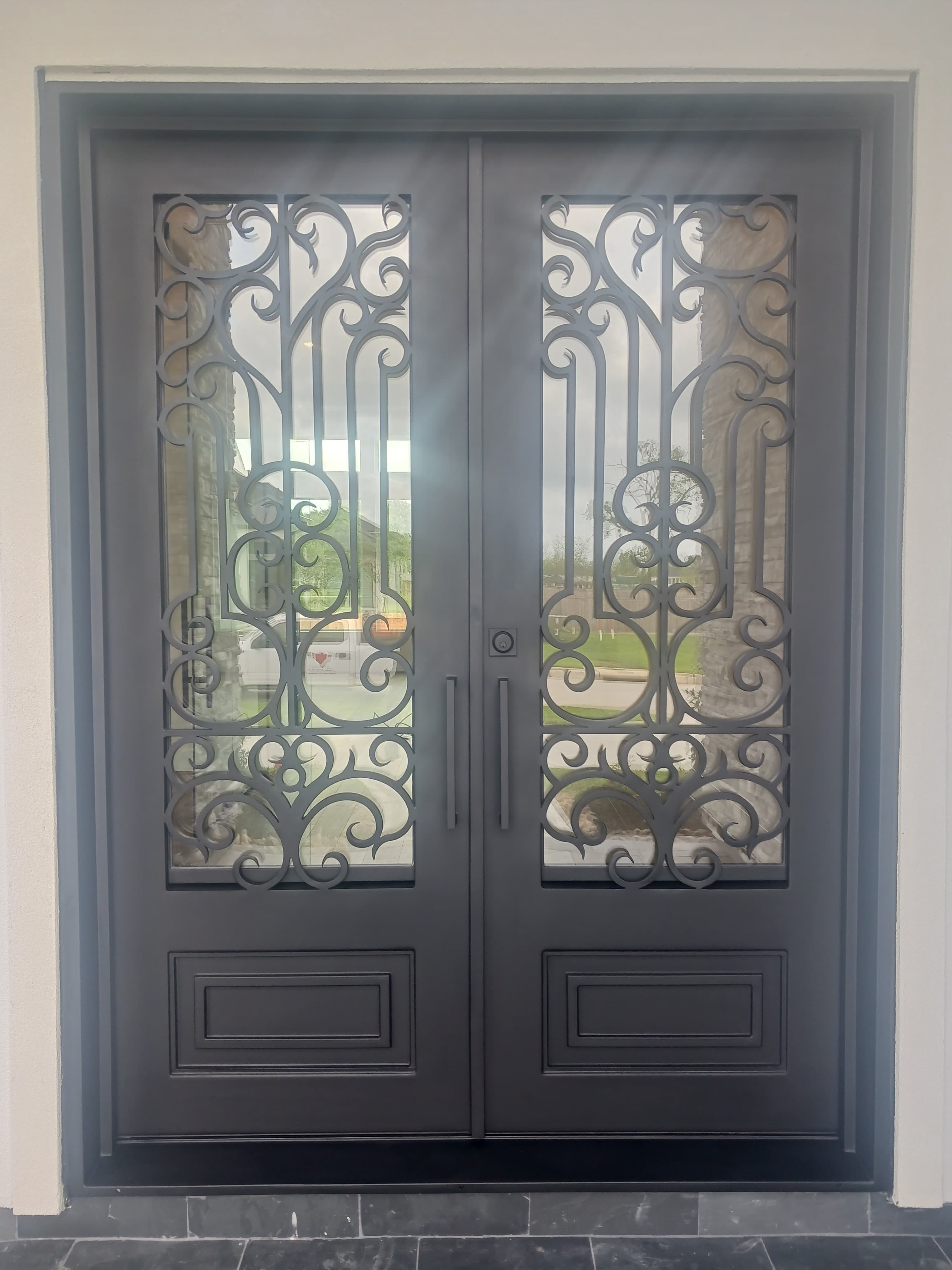 Ornate wrought iron double entry door with scrollwork