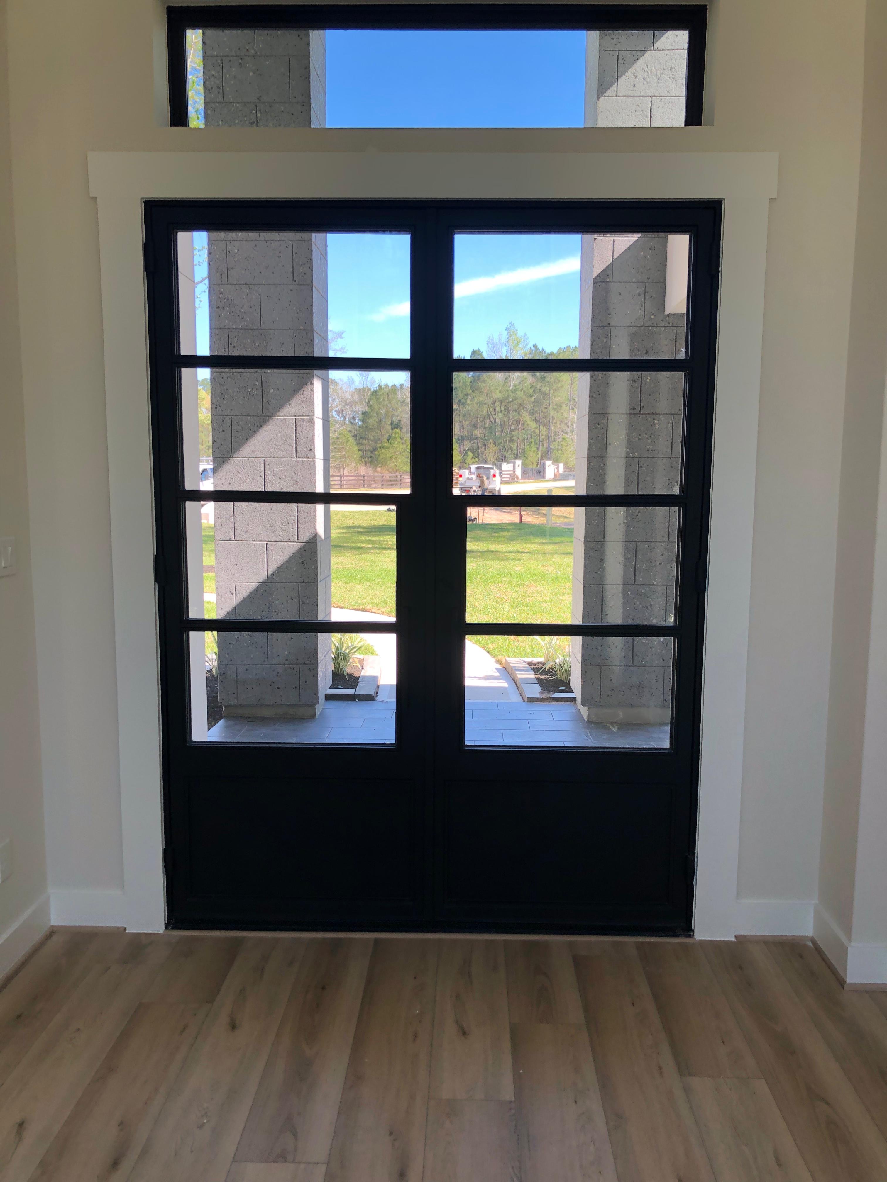 Modern four-panel iron double door with transom