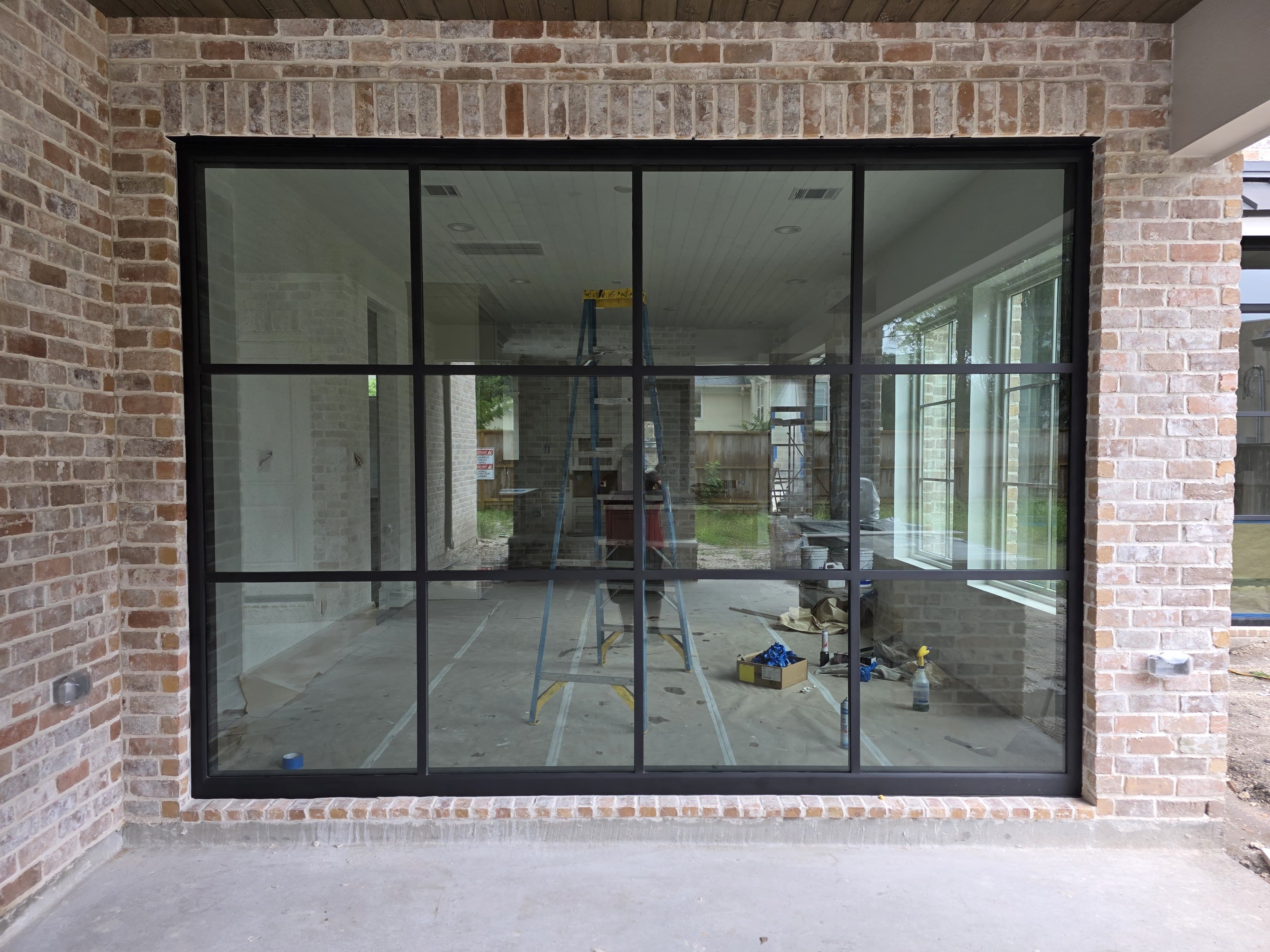 Large steel grid window wall on brick home